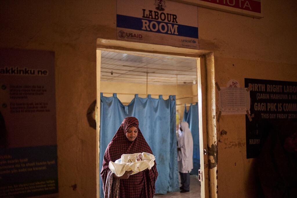 A woman holds a newborn baby inside the labour ward of a hospital in Sokoto state, Nigeria.